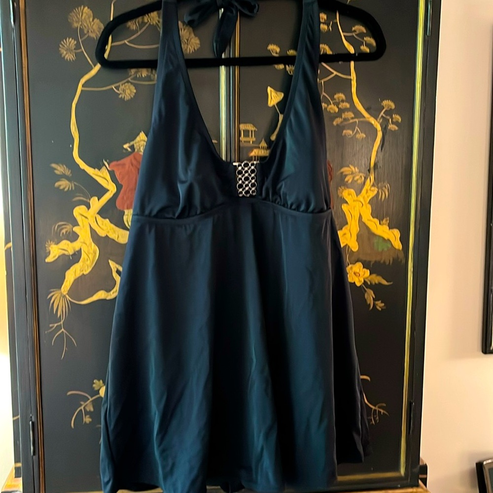 One piece swimsuit with skirt. Black with metal cutout on top.